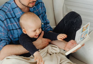Adulte et bébé assis par terre regardent un album