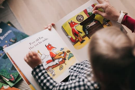 enfant vu de haut regardant un livre